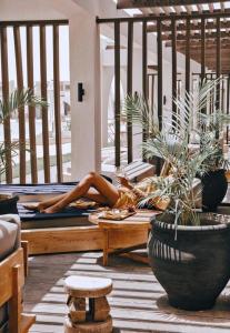 a woman laying on a table in a room with plants at Le Sidi Cabana Near Marassi in El Alamein