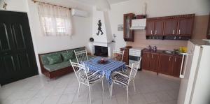 a kitchen with a table and chairs and a couch at OYRANIA -Μαυροβούνι Γυθείου- Σπίτι με θέα in Mavrovoúnion