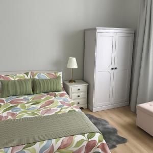a bedroom with a bed and a white cabinet at Seafront Apartment in Newcastle