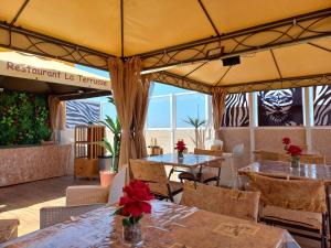 a restaurant with tables and chairs and a tent at Zebra Residence in Rufisque