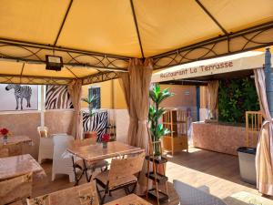 a restaurant with tables and chairs and a tent at Zebra Residence in Rufisque
