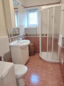 a bathroom with a toilet sink and a shower at sunny apartment in Bol