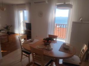 a kitchen and dining room with a table and a window at sunny apartment in Bol +12 photos