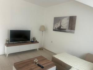 a living room with a flat screen tv on a white wall at Panorama in Negotino