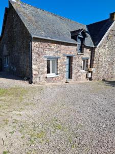 a stone house with a large yard in front of it at La petite maison dans la prairie in Plélan-le-Grand
