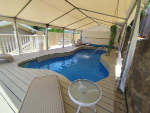 a swimming pool in a tent with a table and chair at Vanilla Grey in Had Nes