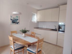 a kitchen with a table and chairs and a kitchen with white cabinets at sunny apartment in Bol