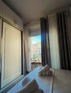 a bedroom with a bed with a large window at Apartament shëngjin lisuss apartments lux in Shëngjin +3 photos