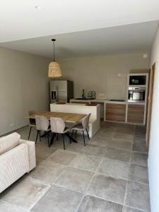 a kitchen and dining room with a table and chairs at Rez-de-villa 65m2 climatisé in Propriano +2 photos