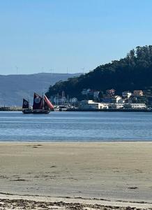 a boat in the water next to a beach at Piso Praia da Rocha in Serres