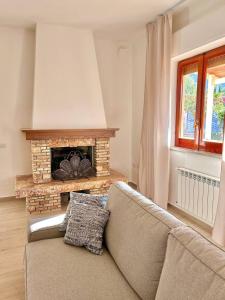 Una sala de estar con un sofá y una chimenea. en Villa Gargaf, en Altavilla Milicia