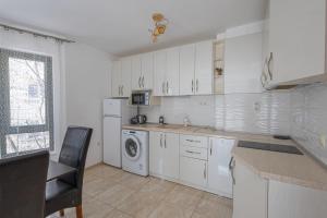 a kitchen with white cabinets and a washer and dryer at Sea Garden Marina 3 in Varna City +18 photos