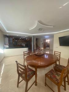 a dining room with a wooden table and chairs at coastal charm harhoura in Temara