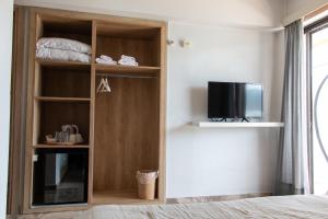 a room with a book shelf with a television at Villa Irene in Poros