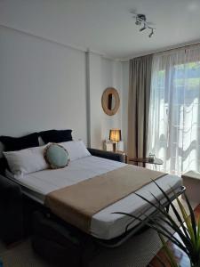 a bedroom with a large bed and a window at Pura Vida Apartmento in Ramales de la Victoria