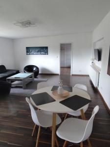 un soggiorno con tavolo e sedie bianche di Ferienhaus Dobberzin nahe Mündesee ad Angermünde