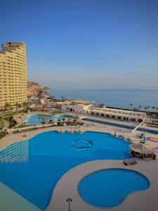 an aerial view of a resort with blue pools at Porto Sokhna Marina Towers sea view in Ain Sokhna