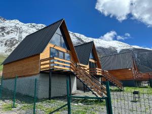 卡兹贝吉A and B Cottages的带有陡峭屋顶和篱笆的房子