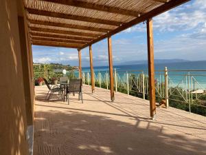 a person sitting at a table on a porch with a dog at Villa Banana in Lourdata