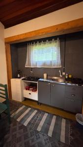 una cocina con fregadero y ventana en Residencial das Araucárias, en Gonçalves