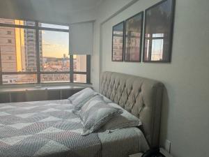 a bedroom with a bed and a view of a city at Flat mobiliado 45 - L Hirondelle in Campinas +56 photos