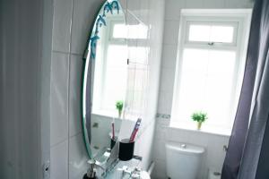 a bathroom with a mirror and a sink at Modern London House With Free Parking & Family Friendly in Edgware