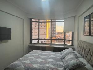 a bedroom with a bed and a large window at Flat mobiliado 45 - L Hirondelle in Campinas
