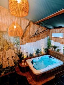 a jacuzzi tub in a room with plants at Les Spas de la mer, Appart&Spa Canopée, 100m de la plage, Love Room in Le Grau-du-Roi