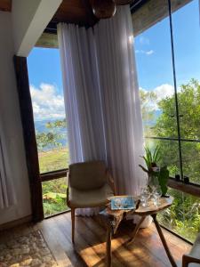 オウロ・プレットにあるSuíte Ad`vinhoのリビングルーム(テーブル、椅子付)、大きな窓が備わります。