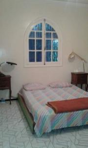 a bedroom with a bed and a window at Houria in Oulad Akkou