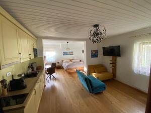 a bedroom with a bed and a living room with a kitchen at Landhaus Marmorata in Sattendorf