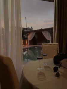 a table with two glasses of wine on it at Vila Eilin - Cozy villa for perfect escapes in Tirana +6 photos