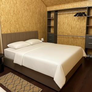 a bedroom with a large white bed and shelves at Vila Eilin - Cozy villa for perfect escapes in Tirana