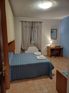 a bedroom with a blue bed and a desk at Villa Fiore in Cerreto di Spoleto