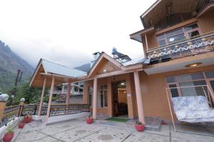 a house with a balcony with a view at The Applewood Villa in Manali Romantic Stay in Manāli