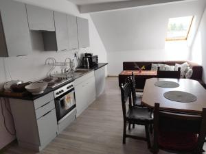a kitchen and dining room with a table and a stove at Agroturystyka Puchatek in Rebiszów
