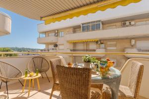 a balcony with a table and chairs and a building at Arquus Little Hawaii in Salou