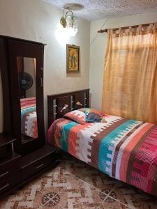 a bedroom with a bed and a mirror at cozy house in Buga Valle in Buga