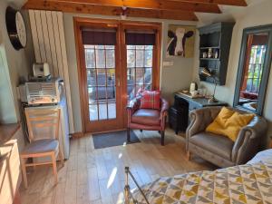 a bedroom with a bed and two chairs and a desk at Kirkstyle Hideaway in Arbroath