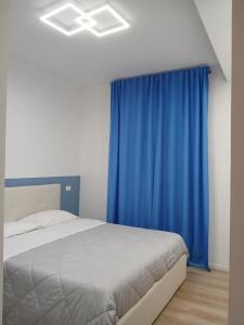 um quarto com uma cama e uma cortina azul em Attico con Terrazzo Panoramico e cucina attrezzata, Nel centro di Giulianova, a due passi dal Mare, Con Servizio biciclette em Giulianova