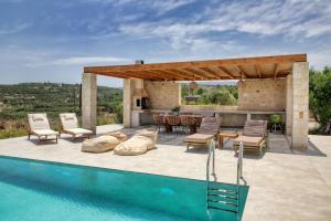 an outdoor patio with a table and chairs next to a pool at Villa Thea sitia in Sitia