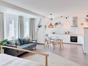 a living room with a couch and a kitchen at Deichstadt Apartments in Neuwied
