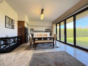 a dining room with a table and a kitchen at Marassi - Luxurious Twin House with Garden in El Alamein
