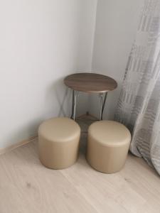 a stool and a table and two stools in a room at GARSONIERĂ in Arad