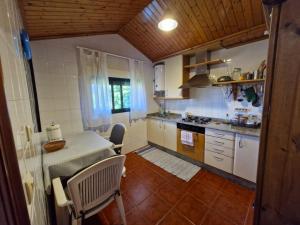 a kitchen with a table and a counter top at Chousiña in Puentesampayo +8 photos