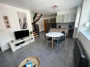 a kitchen and living room with a table and a television at Appart 2 à croix in Croix