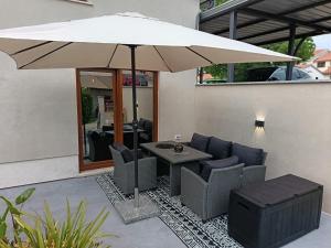 Un patio con una mesa y sillas y una sombrilla. en Luxury New Blue moon, en Poreč