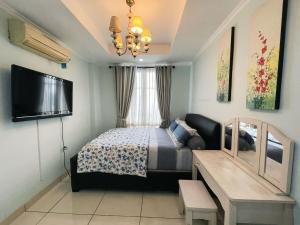 una camera da letto con un letto e una TV a schermo piatto di Cozy and Stategic 1 at cikditiro 2BR pool,gym,wifi By LS a Giacarta