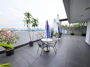 balcone con tavoli, sedie e vista sull'acqua di Cozy and Stategic 1 at cikditiro 2BR pool,gym,wifi By LS a Giacarta