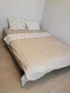 a unmade bed in a bedroom with a white wall at GARSONIERĂ in Arad